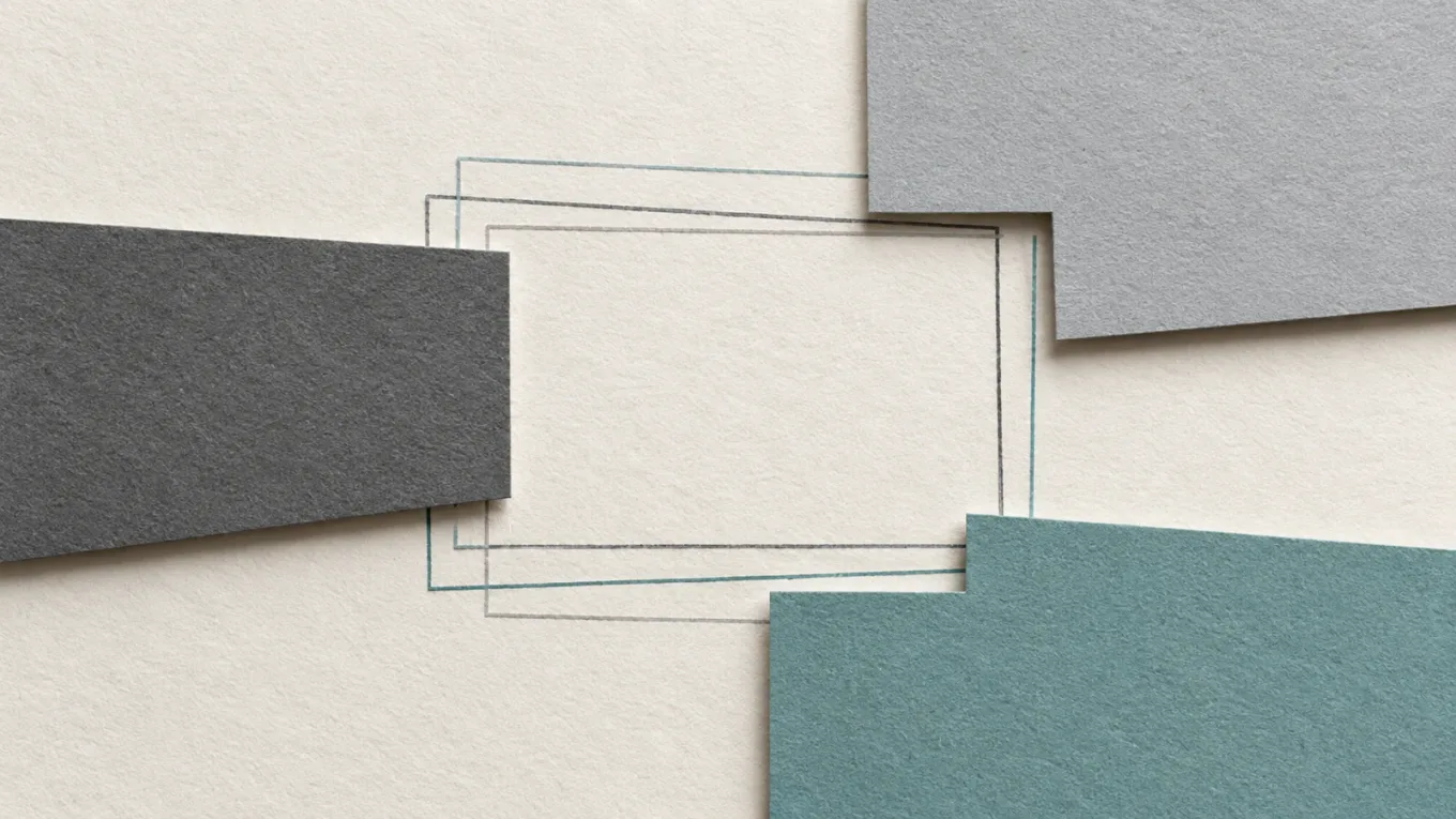 Textured graphite and teal paper shapes framing an open space with offset outlines.